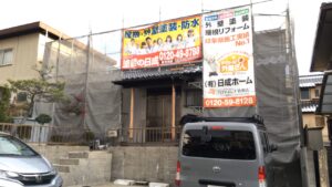 中津川市で外壁塗装を施工中のA様邸です。当社、日成ホームの現場シートが輝いています。